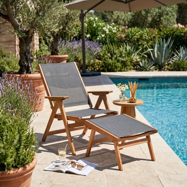 Hölzerner Gartenstuhl mit Hocker auf einer hellen, organisierten Terrasse am Pool, umgeben von Pflanzen.