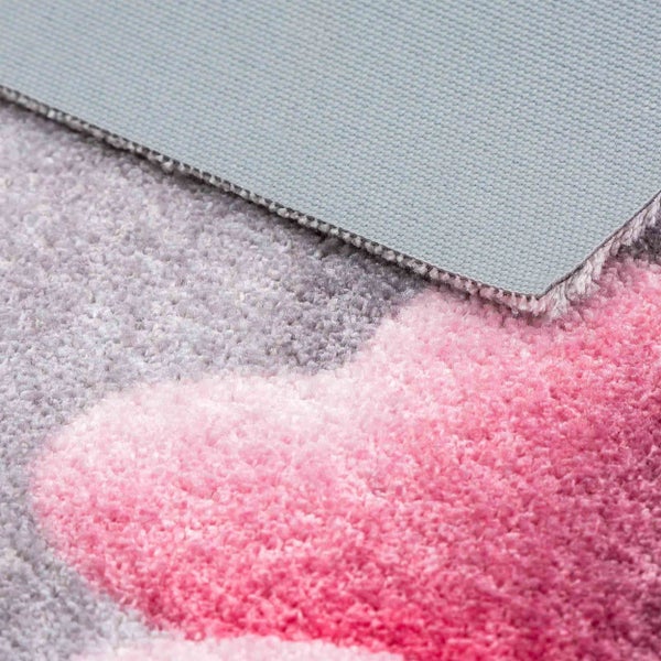 Detailansicht eines flauschigen Teppichs mit Herzmotiv und rutschfester Unterseite.