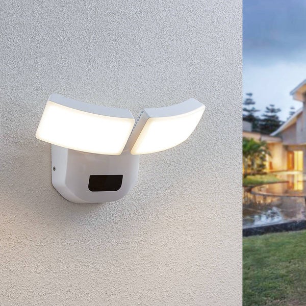 Zweiflammige LED Außenwandleuchte mit Bewegungsmelder in Weiß an einer verputzten Fassade montiert.