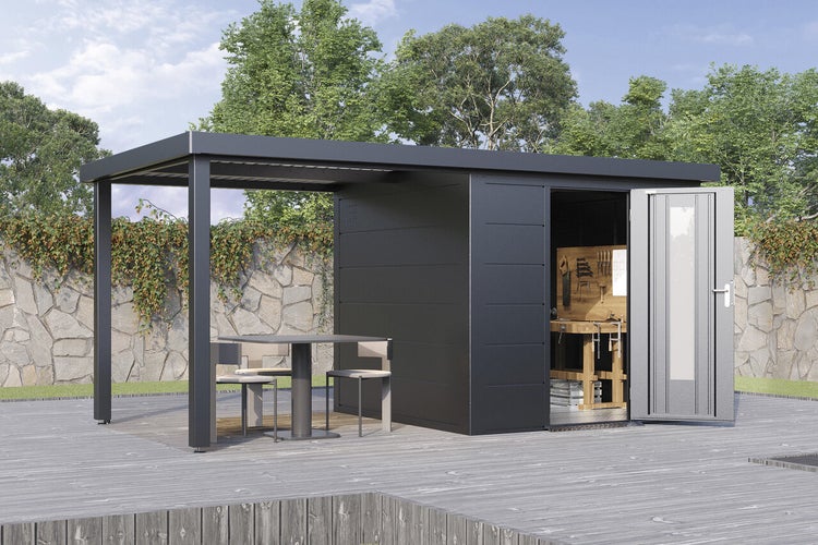 Modernes Gartenhaus aus Metall mit integriertem Terrassendach, Werkbank im Innenraum und Sitzbereich auf einer Holzterrasse vor einer Steinmauer.