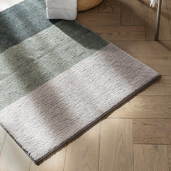 Mehrfarbige Badematte auf Holzboden