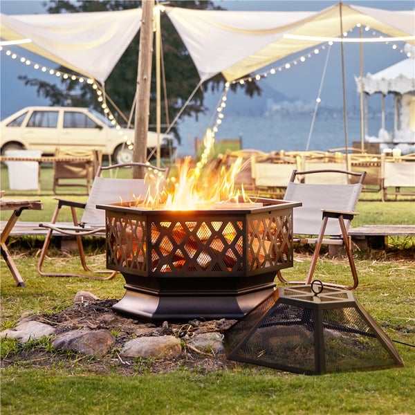 Feuerstelle mit Funkenschutzgitter und Holz