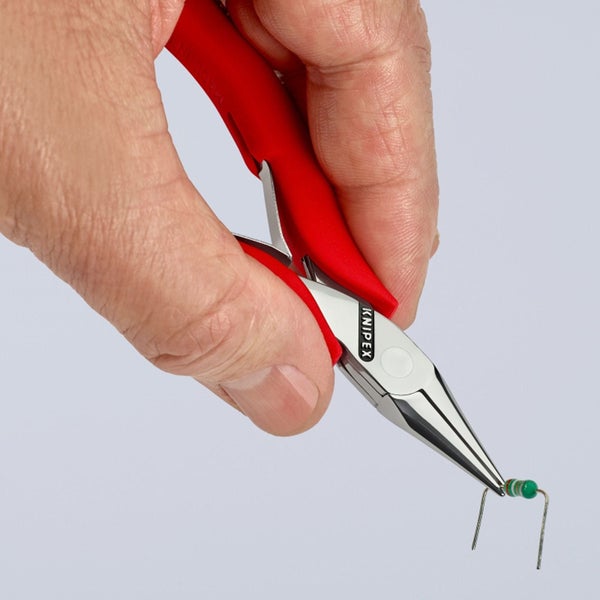 Eine Hand hält eine Knipex-Zange, die ein elektronisches Bauteil greift.