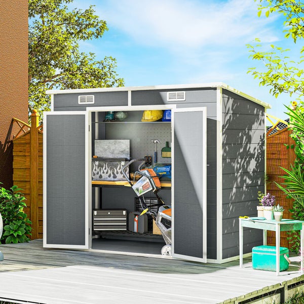 Graues Gerätehaus mit weißen Rahmen und offenen Türen auf einer Holzterrasse, gefüllt mit Werkzeugen und Zubehör.