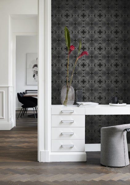 Szene mit gemusterten Tapeten, einem weißen Schreibtisch und einem Stuhl