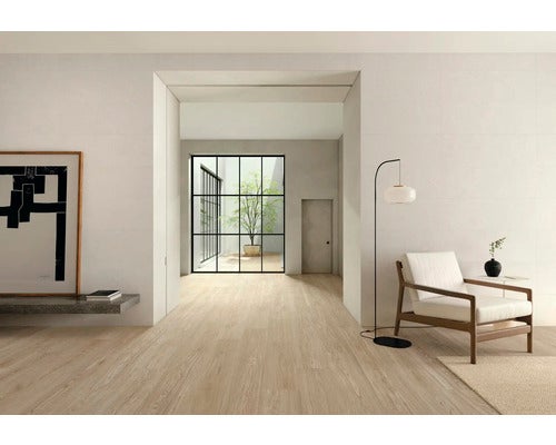 Heller Raum mit Holzfußboden, Sitzbereich und Durchgang zum Garten