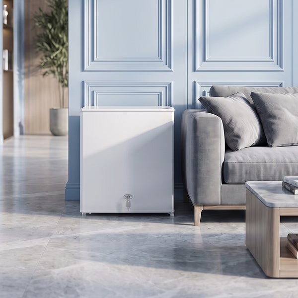Ein freistehender Mini Kühlschrank mit Schloss in einem modern eingerichteten Wohnzimmer neben einem grauen Sofa auf einem Marmorboden.