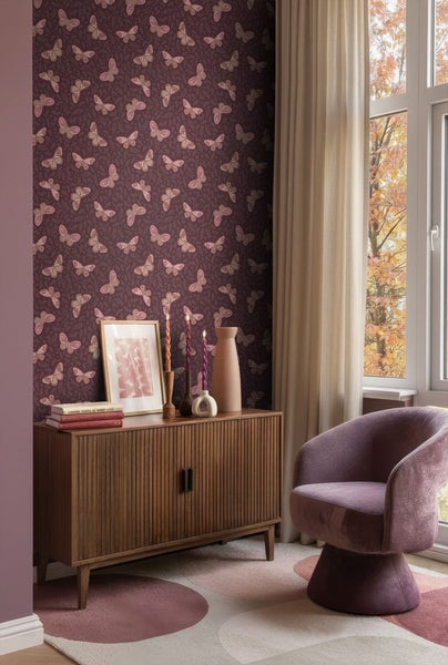 Wohnzimmer mit Kommode, Sessel und Tapete mit Schmetterlingsmuster