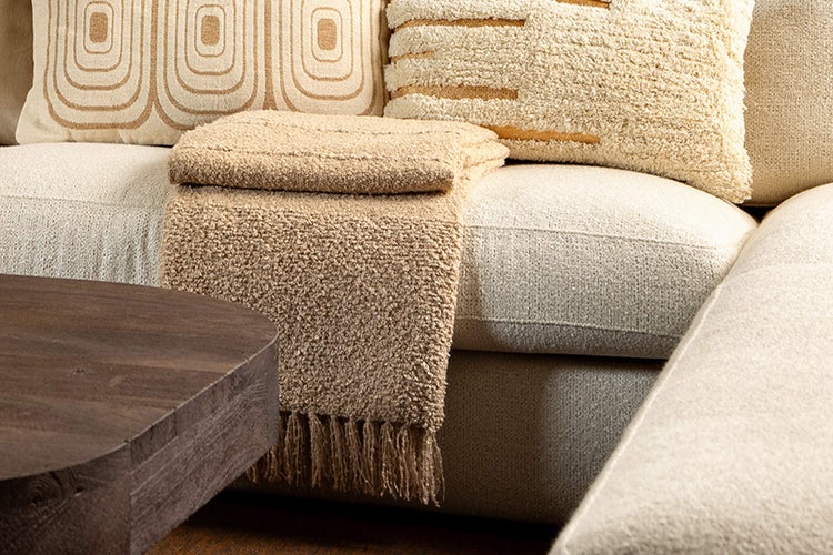 Dekorative Kissen mit geometrischen Mustern und eine Tagesdecke auf einem Sofa