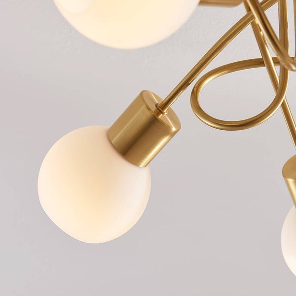 Nahaufnahme einer Deckenleuchte mit goldenem Gestell und mehreren runden Lampenschirmen