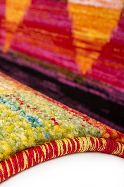 Nahaufnahme eines bunt gemusterten Teppichs mit weicher Textur und gekettelter Kante.