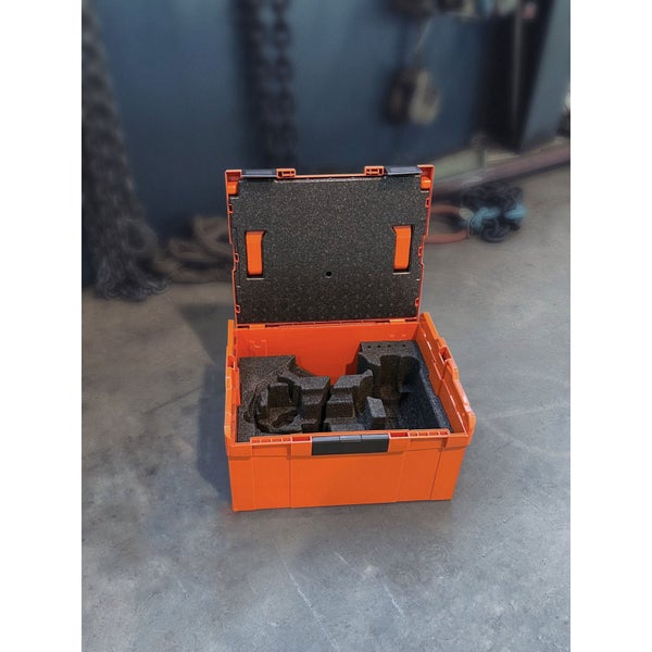 Oranger Werkzeugkoffer aus Kunststoff mit Schaumstoffeinlage und Maschinenschraubstock auf Werkstattboden