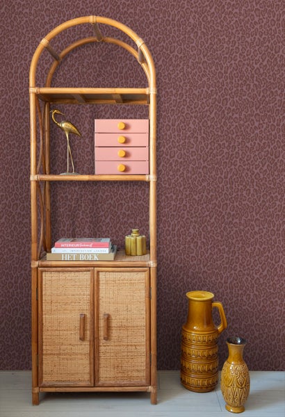 Vliestapete mit Leopardenmuster an der Wand in einem Zimmer mit Bambusregal.