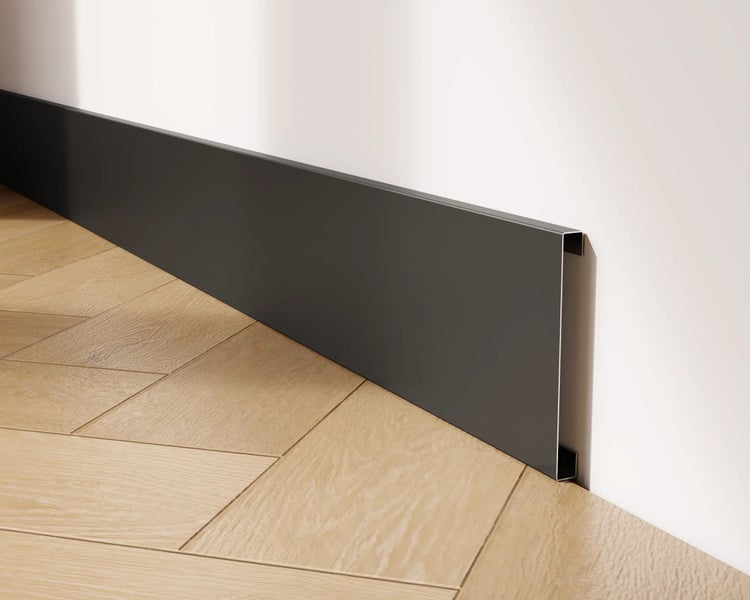 Sockelleiste aus Metall an einer Wand mit Holzboden