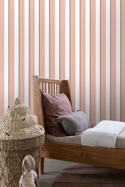 Gestriifte Tapete mit Kinderbett und Spielzeugkorb im Raum.