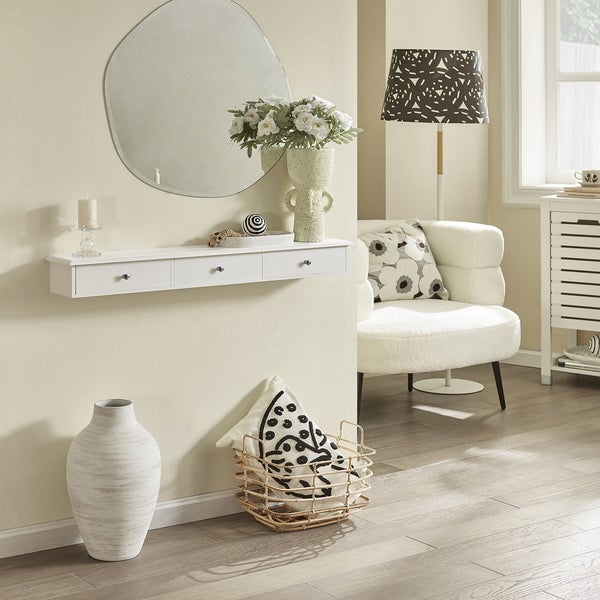 Wohnraum mit Spiegel, Wandkonsole mit Schubladen, Sessel, Stehlampe und Dekoration