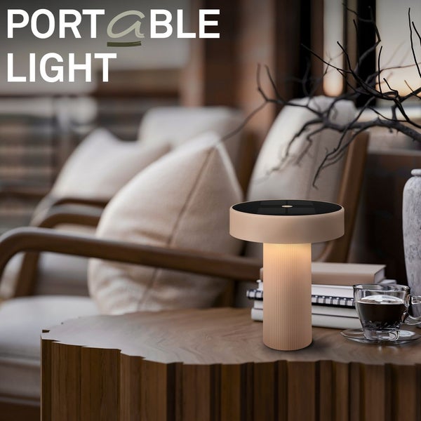 Moderne tragbare Tischleuchte mit Solarpanel auf einem Holztisch in einem hell eingerichteten Wohnbereich.