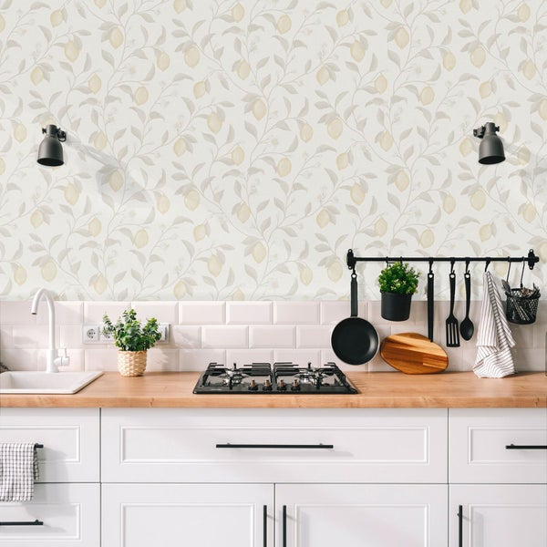 Küchenszene mit weißen Schränken, hölzerner Arbeitsplatte und Zitronentapete