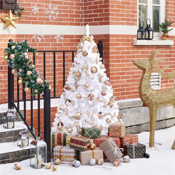Festliche Dekoration vor einem Backsteinhaus mit Weihnachtsbaum, Geschenken und goldenem Rentier