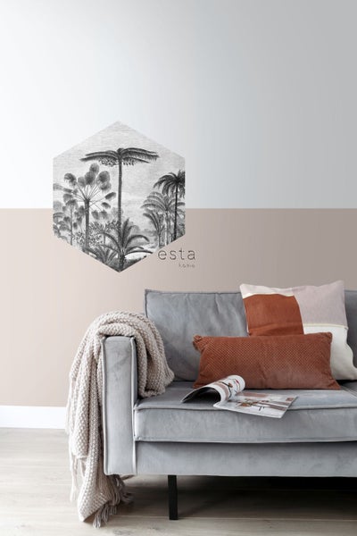 Wohnzimmer mit Wandtattoo im Dschungelstil, Sofa, Kissen und Zeitschrift