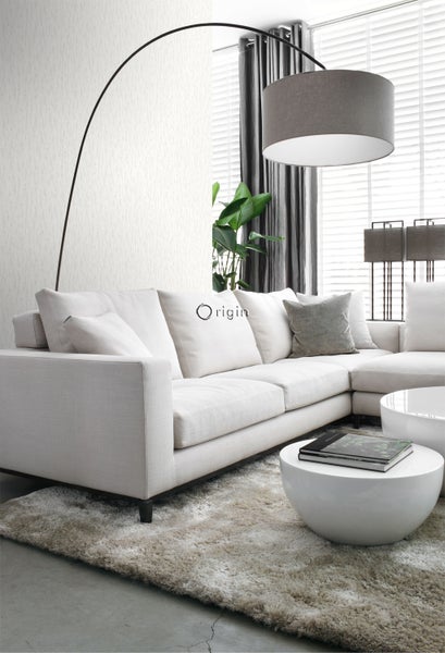 Helles Wohnzimmer mit Ecksofa, Bogenlampe und runden Tischen auf einem Teppich