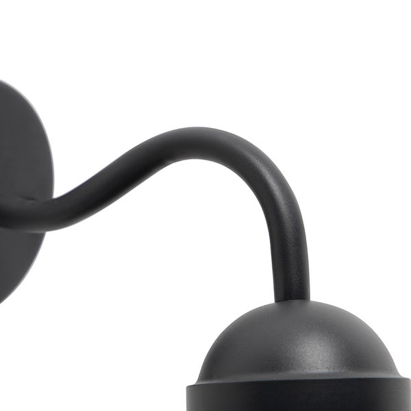 Nahaufnahme einer Wandleuchte für den Außenbereich mit einem geschwungenen Lampenarm aus schwarzem Metall.