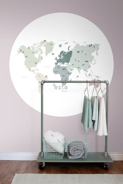 Dekorative Weltkarte an einer Wand mit Rollgarderobe, Körben und Textilien im Kinderzimmer.