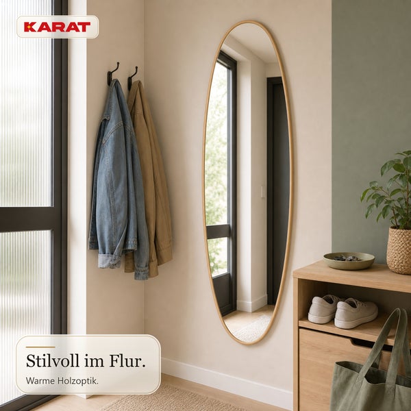 Flur mit ovalem Spiegel mit Holzrahmen, Wandhaken mit Jacken, einem Holzschrank und Zimmerpflanze, Karat Logo.