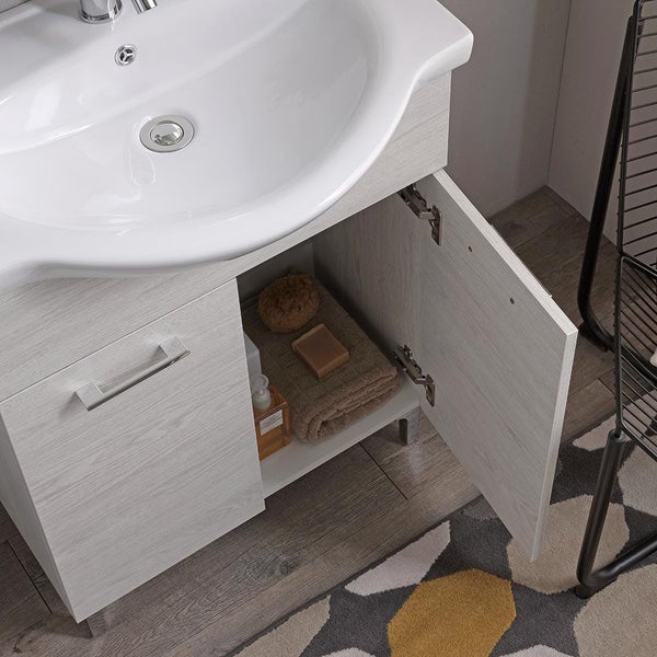 Badezimmer-Waschbeckenunterschrank mit weißem Keramikwaschbecken und hellem Holzdekor, eine geöffnete Tür zeigt Innenablage.