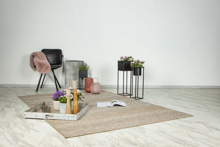 Wohnzimmerdekoration mit Teppich, Stuhl, Blumenständern, Tablett und Laternen in einem modernen Raum mit Marmorboden.