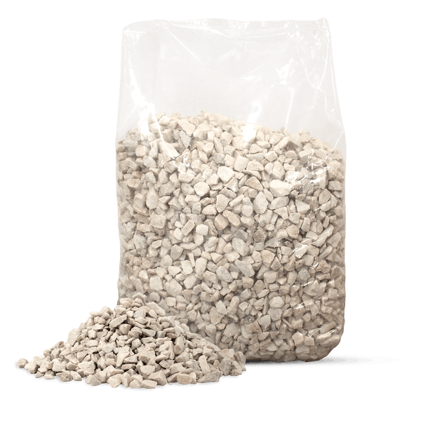 Heller Ziersplitt aus Naturstein im transparenten Beutel mit einer kleinen Materialprobe davor.