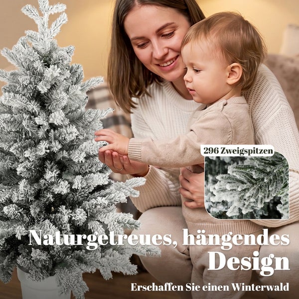 Mutter und Kind betrachten einen künstlichen, verschneiten Weihnachtsbaum mit 296 Zweigspitzen im Innenbereich.