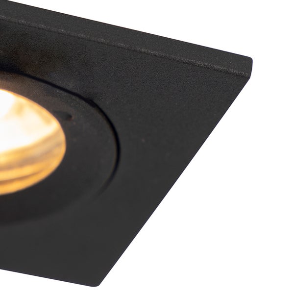 Nahaufnahme einer quadratischen, schwarzen Deckenleuchte aus strukturiertem Metall mit eingeschaltetem runden Strahler.