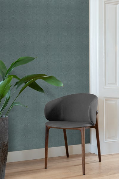 Raum mit gemusterter Tapete, Zimmerpflanze und Stuhl