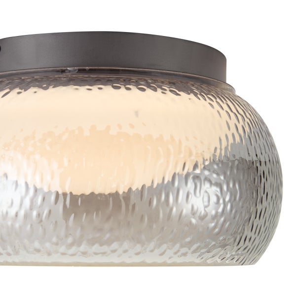 Moderne Deckenleuchte mit texturiertem Glasschirm und dunklem Metallsockel für eine wohnliche Beleuchtung.