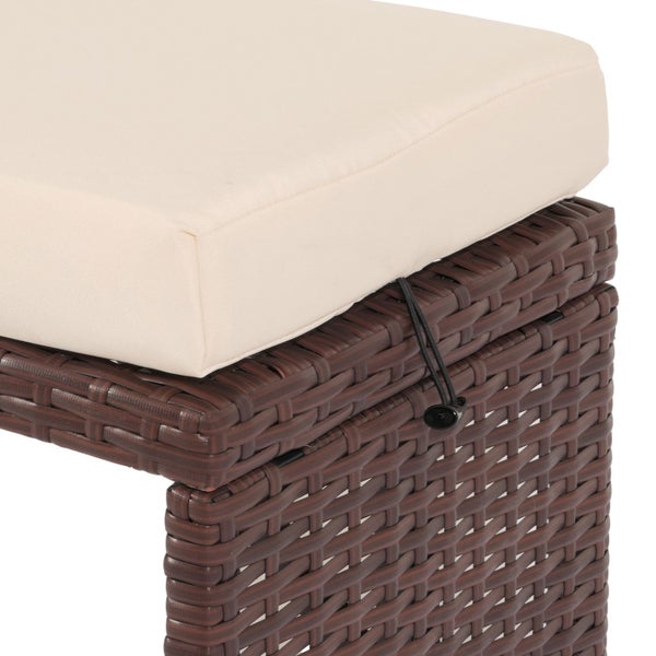 Detailansicht eines braunen Gartenhockers aus Polyrattan mit beigem Sitzkissen und schwarzer Kordelbefestigung.