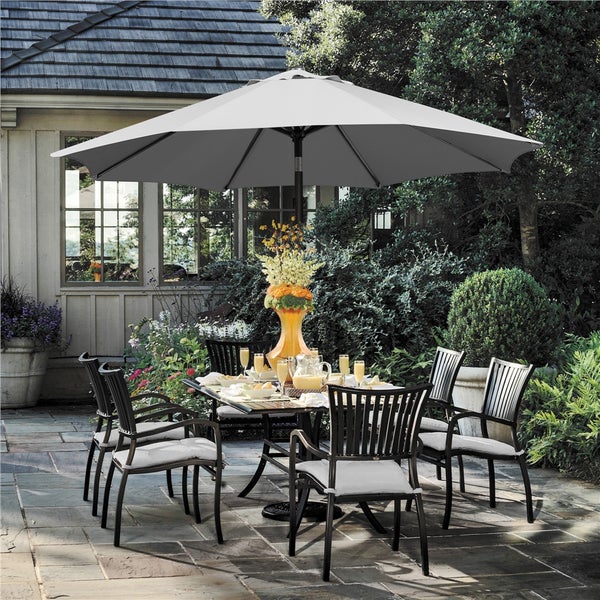 Gartenszene mit Esstisch, Stühlen und Sonnenschirm