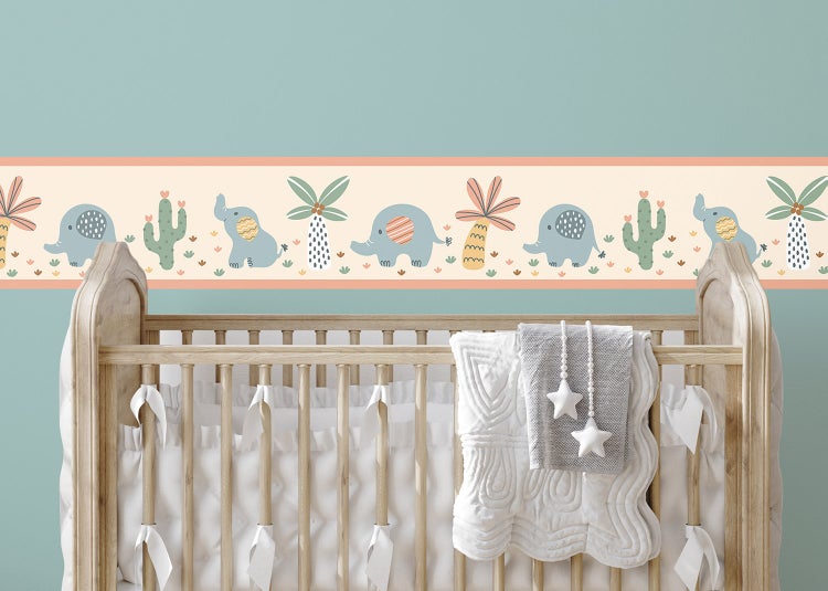 Selbstklebende Tapetenbordüre mit Elefanten, Palmen und Kakteen im Kinderzimmer über einem hölzernen Babybett.