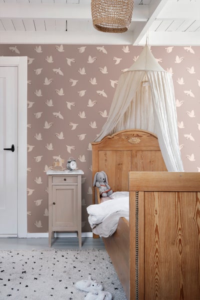 Kinderzimmer mit Holzbett, Nachttisch und Tapete mit Vogelmotiv
