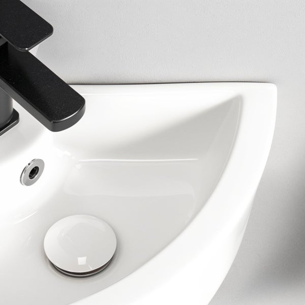 Eckwaschbecken aus Keramik mit Armatur und Ablaufventil zur Wandmontage