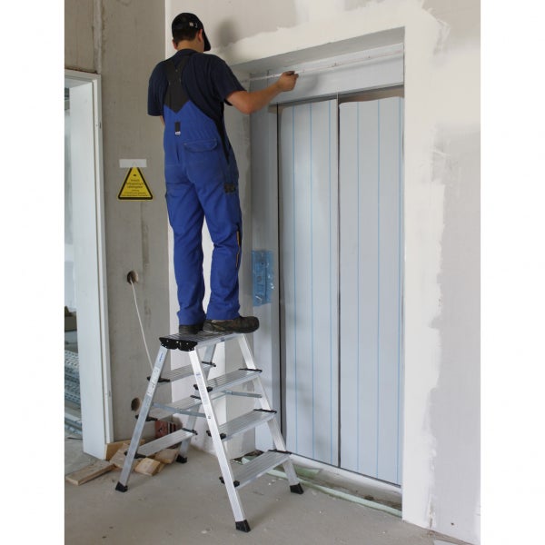 Handwerker misst einen Aufzug von einer Stufenleiter aus