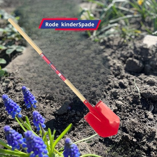 Roter Kinderspaten mit Holzstiel im Garten