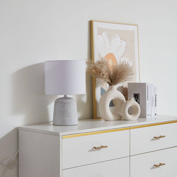 Dekorative Inneneinrichtung mit Lampe, Vase, Kunst und Kommode