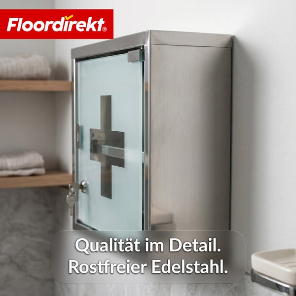 Medizinschrank aus rostfreiem Edelstahl mit Glastür und Erste-Hilfe-Symbol, abschließbar mit Schlüssel, Floordirekt Logo.