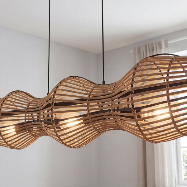 Dreiflammige Pendelleuchte aus Rattan mit gewelltem Schirm und sichtbaren Leuchtmitteln.