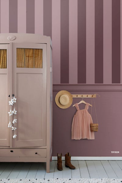 Wandgestaltung im Kinderzimmer mit vertikalen Streifen in Altrosa, einem Vintage-Kleiderschrank aus Holz, einer Hakenleiste und Holzdielen.