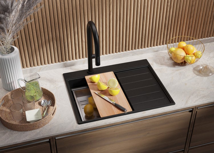 Schwarze Küchenspüle mit Schneidebrett und Zitrone auf einer Küchentheke