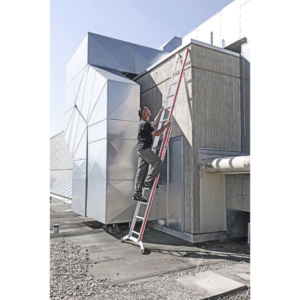 Mann steigt auf einer Leiter an einem Gebäude hoch.