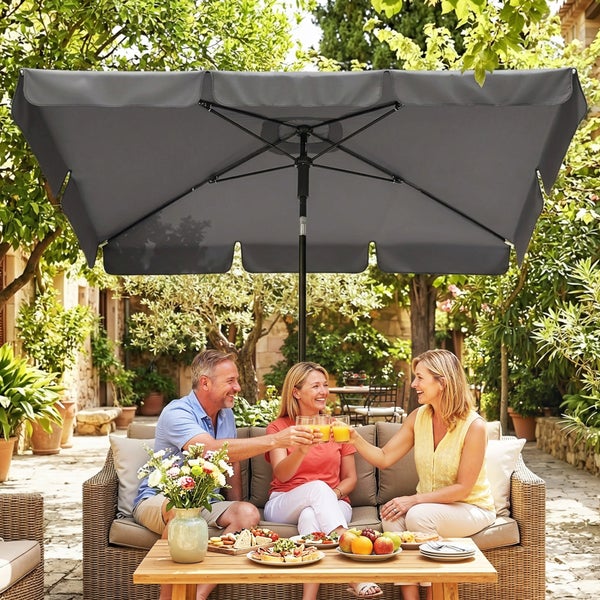 Rechteckiger Sonnenschirm in Grau auf einer Terrasse über einer gemütlichen Lounge-Ecke mit Sitzgruppe im Garten.