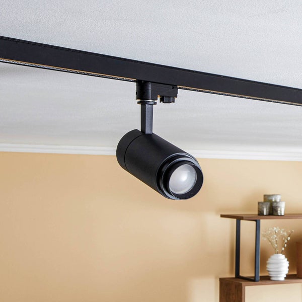 Schwarzer LED-Strahler für ein Schienensystem, an der Decke montiert in einem hellen Wohnraum.